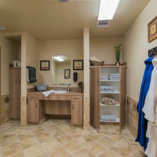 A well-organized bathroom featuring a spacious vanity, shelves for storage, and warm lighting.
