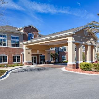 A welcoming entrance to a residential building, set against a clear blue sky.
