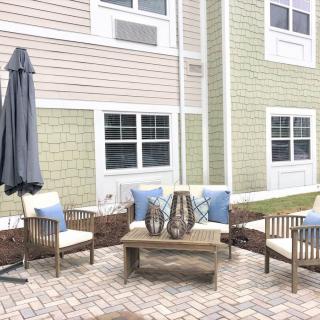 A cozy outdoor patio area with seating and an umbrella.