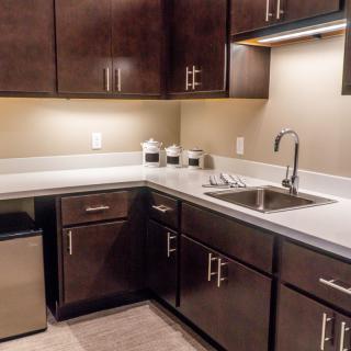 A modern kitchen with dark wood cabinets and a sleek countertop.