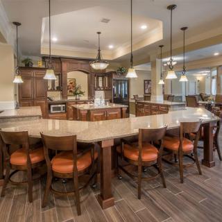 A spacious kitchen with a large island, ample seating, and elegant pendant lighting.
