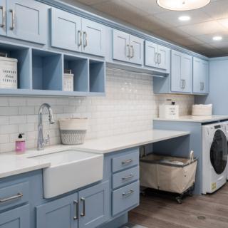 A modern laundry room featuring blue cabinets, a large sink, and a washing machine with ample storage space.