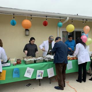 A gathering with a food table decorated for a festive outdoor event.