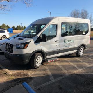 A white van parked in a parking lot on a sunny day.
