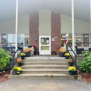 A welcoming entrance with floral arrangements and a spacious staircase leading to the building.