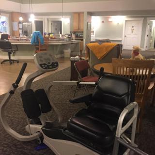 A cozy indoor space featuring exercise equipment alongside a dining area and comfortable seating.
