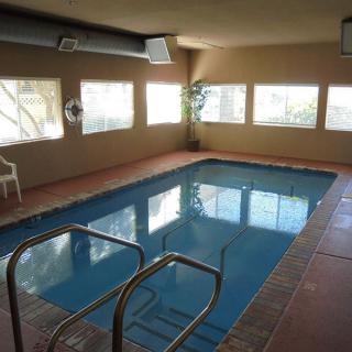 An indoor swimming pool with large windows and seating area.