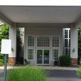 The image shows the entrance of a building with a canopy and large windows.