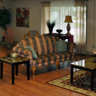 A cozy living room with a striped sofa, coffee table, and ambient lighting.