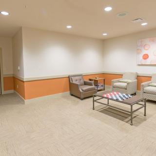 A modern waiting room with comfortable chairs and a coffee table.