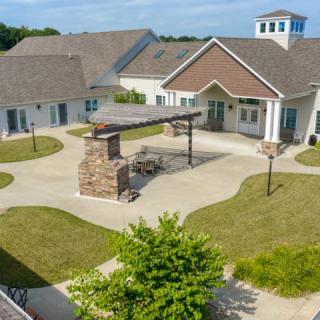 An aerial view of a residential complex with a central courtyard and landscaped surroundings.