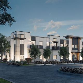 Modern apartment complex at dusk with surrounding trees.