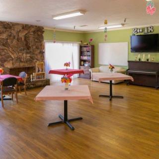 A cozy and spacious dining area with tables, chairs, and a television.