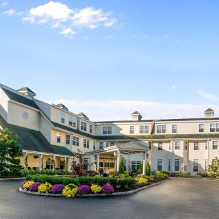 A charming hotel with a well-maintained entrance and landscaping under a clear blue sky.