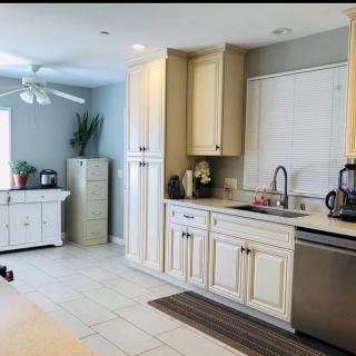 A modern kitchen with white cabinets, a sink, and stainless steel appliances.