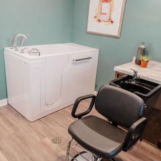 A bathroom with a walk-in bathtub and a salon-style chair.