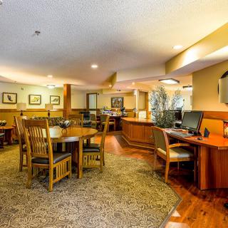 A well-furnished office space featuring wooden tables and chairs arranged for meetings.