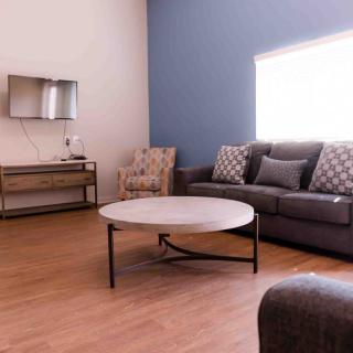 A modern living room with a sofa, armchair, and coffee table.
