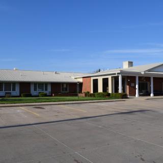 A view of a multi-winged commercial building under a clear blue sky.