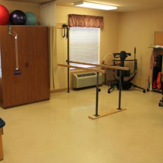 A physical therapy room equipped with various exercise tools and equipment for rehabilitation.