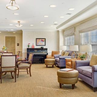 A cozy living room with comfortable seating and a piano.