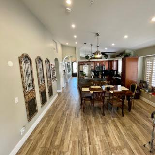 A stylish open-concept kitchen and dining area featuring contemporary design elements and warm wood flooring.