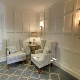 A cozy living room corner with upholstered chairs and a soft rug.