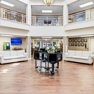 Spacious lobby with a grand piano and elegant decor.