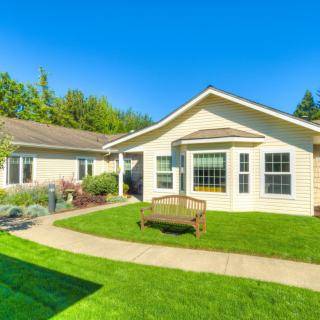 A beautiful house with a well-maintained lawn and a paved pathway on a sunny day.