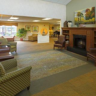 A welcoming lobby area featuring comfortable seating, a cozy fireplace, and decorative artwork.