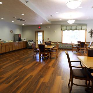 A spacious and inviting dining area featuring wooden floors and a warm atmosphere.