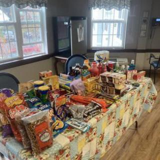 A table filled with a variety of snacks displayed indoors by a window.