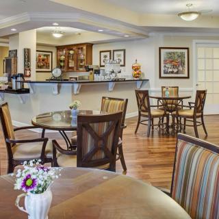 A cozy cafe with neatly arranged tables and chairs, featuring warm decor and inviting ambiance.