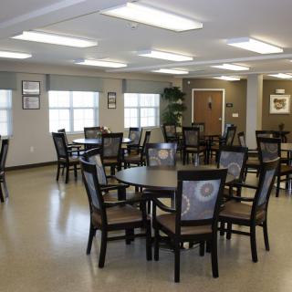 An empty dining room with multiple tables and chairs arranged neatly.