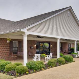 A cozy building with a covered porch and well-manicured landscaping.