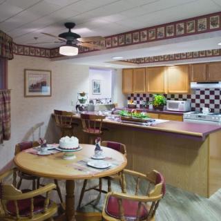 A cozy kitchen and dining area with wooden furniture and a decorative border.