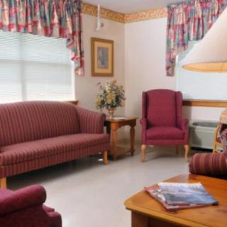 A cozy living room with a sofa, armchair, and floral decor.
