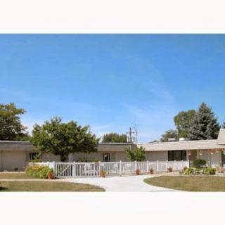 A beautiful residential home with a well-maintained garden and blue sky in the background.