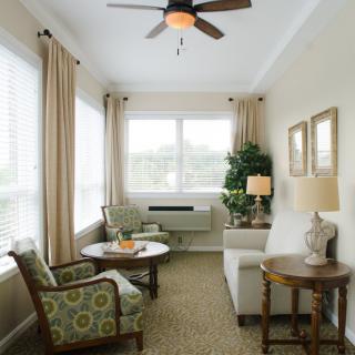 A cozy living room with comfortable seating, a coffee table, and large windows allowing natural light.
