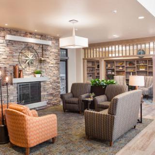 A cozy lounge area featuring comfortable seating, a stone accent wall, and warm lighting.