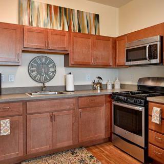A modern kitchen with wooden cabinets and stainless steel appliances.