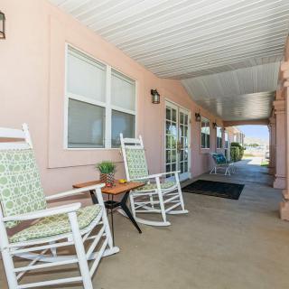 A cozy porch with rocking chairs and a covered walkway.