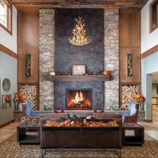 A cozy living room with a stone fireplace and rustic decor.