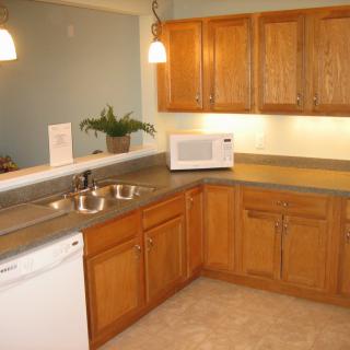 A cozy kitchen with wooden cabinets and modern appliances.