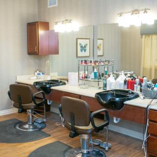 A view of a well-equipped hair salon interior with barber chairs and beauty products.