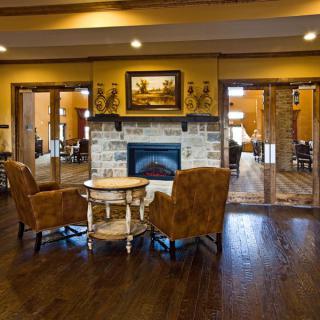 A cozy lounge area with a fireplace and two chairs facing each other.