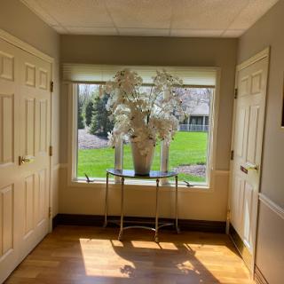A bright and inviting hallway with a decorative vase of flowers by the window.