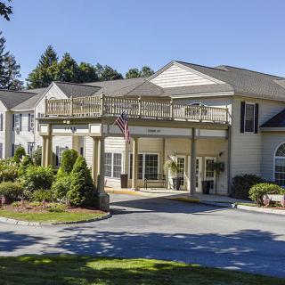A well-maintained residential building with landscaped surroundings and clear blue skies.