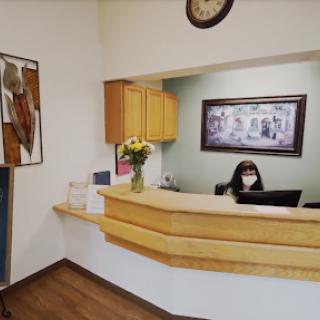 A warm and welcoming reception area featuring a staff member at the desk.