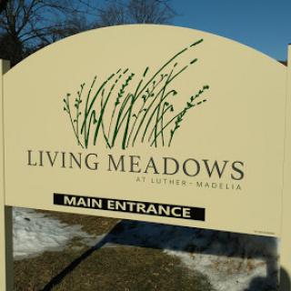 Main entrance sign for Living Meadows, highlighting a connection with nature.